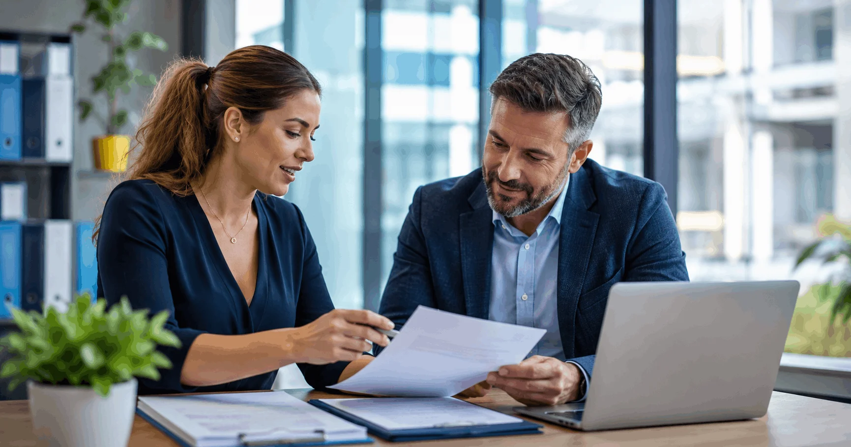 Business manager reviewing labour hire compliance documents with recruitment consultant